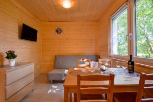a dining room with a table and a couch at Domki Nadmorski Skarb Ostrowo k/Karwi in Ostrowo