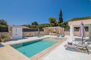 a swimming pool with two chairs and an umbrella at Le Mar Villa in Vasilikos