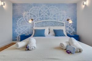 a bedroom with a large white bed with towels on it at Villa Silencia in Pag