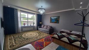ein Schlafzimmer mit einem Bett, einem Sofa und einem Fenster in der Unterkunft Guest house B&B in Kochkorka