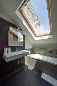een badkamer met een wastafel en een dakraam bij Mansarda Napoli Sky By Dimorra in Napels
