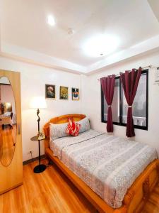 1 dormitorio con 1 cama grande y cortinas rojas en Retreat to a Stylish Flat w/ Balcony + Garden View en Liloan