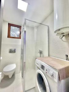 uma casa de banho com uma máquina de lavar roupa e um WC em Redondo Apartments Budva em Budva