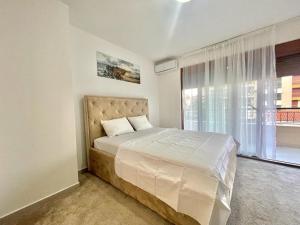 um quarto com uma cama e uma grande janela em Redondo Apartments Budva em Budva