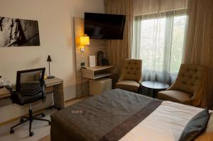 um quarto de hotel com uma cama, uma secretária e uma cadeira em Hotel Pommern em Mariehamn