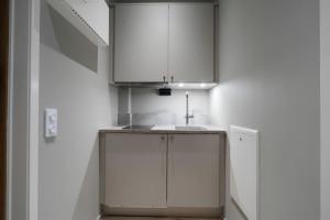 uma cozinha com armários brancos e um lavatório em Tott studios em Åre