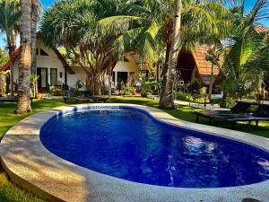 une piscine dans une cour avec des palmiers dans l'établissement Gili Land, à Gili Air