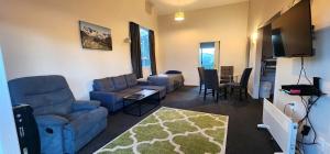 ein Wohnzimmer mit einem blauen Sofa und einem Tisch in der Unterkunft Acorn Estate Motel in Masterton