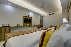 a hotel room with two beds and a flat screen tv at Hotel The Prithvi, Near Delhi Airport in New Delhi