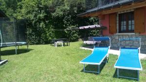 a group of blue chairs sitting in the grass at La Casa Rossa - Presolana in Castione della Presolana