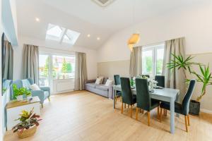 a living room with a table and chairs and a couch at Apartamenty Lighthouse - Premium Dźwirzyno in Dźwirzyno