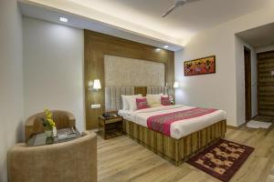 1 dormitorio con cama, escritorio y silla en Hotel The Prithvi, Near Delhi Airport en Nueva Delhi