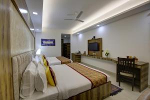 Habitación de hotel con 2 camas y TV en Hotel The Prithvi, Near Delhi Airport en Nueva Delhi