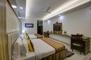 a hotel room with two beds and a television at Hotel The Prithvi, Near Delhi Airport in New Delhi