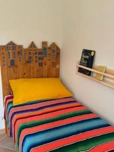 Una cama con una manta colorida en una habitación en Pink House, en Perdifumo
