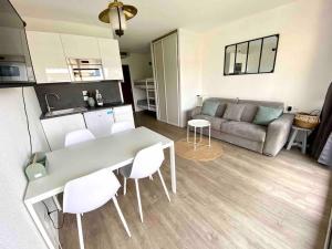 cocina y sala de estar con mesa y sillas. en Superbe studio avec terrasse - Port de Saint Laurent du Var, en Saint-Laurent-du-Var