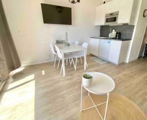 a kitchen with a table and chairs in a room at Superbe studio avec terrasse - Port de Saint Laurent du Var in Saint-Laurent-du-Var