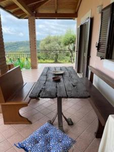 una mesa de madera en un patio con vistas a un balcón en Pink House, en Perdifumo