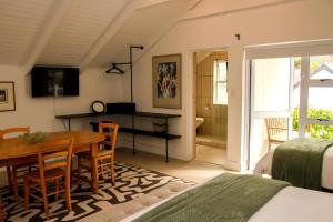 a bedroom with a dining room table and a bed at Hermanus Champagne Accommodation in Hermanus