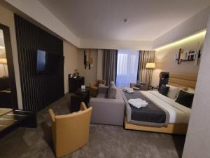 a hotel room with a large bed and a couch at Comfort Hotel Astana in Astana