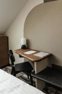 un pequeño escritorio con 2 sillas y una lámpara en la pared en Hotel GIN Budapest en Budapest