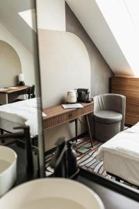 Habitación con 2 camas, mesa y silla en Hotel GIN Budapest, en Budapest