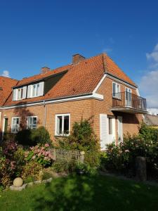 una casa in mattoni con balcone e cortile di Bed & Kitchen i Højer a Højer