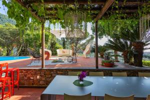 a patio with a table and chairs and a pool at Villa Meridiana luxury property in Camogli in Camogli