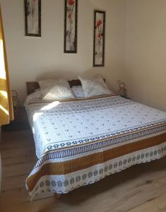 1 dormitorio con 1 cama con manta azul y blanca en L'Annexe, en Sigean