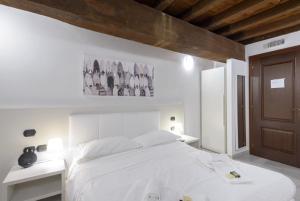 1 dormitorio blanco con 1 cama blanca y 2 mesas en Flowers Apartments, en Roma