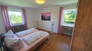 sypialnia z łóżkiem i 2 oknami w obiekcie Ferienwohnung Melinda w Füssen