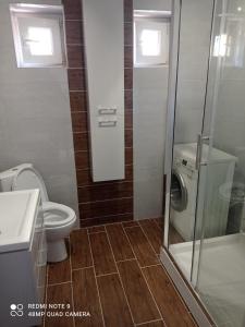 a bathroom with a toilet and a washing machine at Hostel Wiśniowa 55 in Wrocław