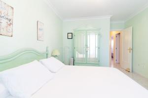ein weißes Schlafzimmer mit einem weißen Bett und einem Fenster in der Unterkunft Global Properties, Acogedor adosado en la playa de Corinto in Sagunt