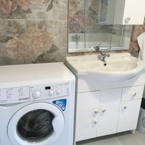 a bathroom with a washing machine and a sink at Villa Rosa Centre in Balatonfüred