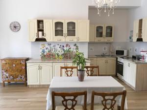 a kitchen with white cabinets and a table with a plant on it at Villa Rosa Centre in Balatonfüred