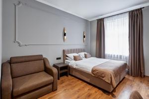 a bedroom with a bed and a chair at Hotel Classic in Kyiv