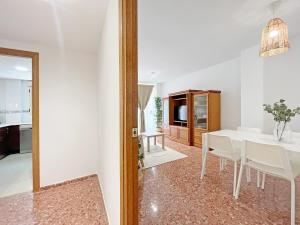 une salle à manger avec une table blanche et des chaises blanches dans l'établissement Global Properties, Apartamento de 3 dormitorios en Sagunto, à Sagonte