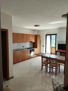 a kitchen with wooden cabinets and a table and chairs at Casa Sartori in Caderzone Terme