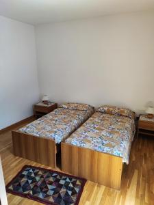 two beds in a room with two rugs at Casa Sartori in Caderzone Terme +1 photo