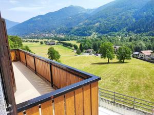 a balcony with a view of a field and mountains at Casa Sartori in Caderzone Terme