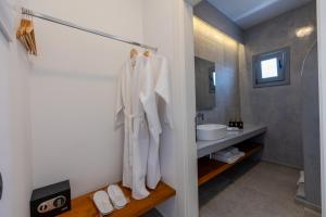 La salle de bains est pourvue d'un lavabo et d'un miroir. dans l'établissement Bonsai Luxury Suites, à Karterados