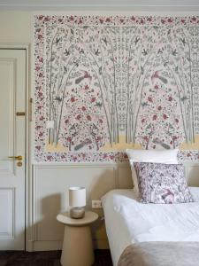 1 dormitorio con 1 cama y papel pintado con motivos florales en 't Hotel, en Ámsterdam