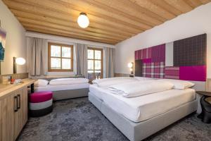 a bedroom with two beds and a wooden ceiling at Kinder- & Gletscherhotel Hintertuxerhof in Tux