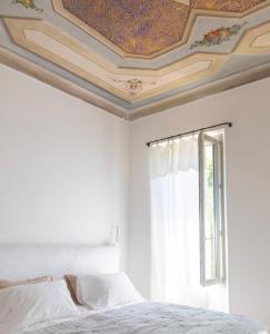 um quarto com um tecto em caixote e uma cama em La Bâtisse en Blanc em Golfe-Juan