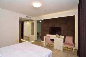 um quarto com uma cama, uma secretária e uma televisão em M2 Hotel em Campi Bisenzio