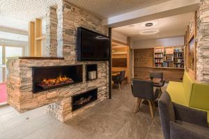 a living room with a fireplace and a tv at Landhotel Kirchenwirt in Unken