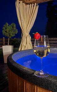 a glass of wine and a strawberry on a hot tub at Dom na Zielonym Wzgórzu z własną Sauną i Jacuzzi in Łapsze Niżne