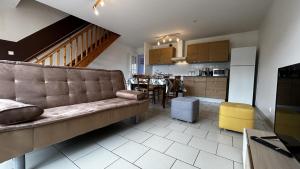 un salon avec un canapé et une cuisine dans l'établissement Mayocq 1, charmante maison avec jardin, au Crotoy