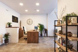 an office with a desk in a room with potted plants at Charm Hotel, Hersonissos in Hersonissos