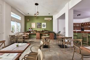 a restaurant with green walls and tables and chairs at Charm Hotel, Hersonissos in Hersonissos